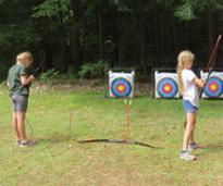 girls at summer camp doing archery