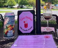 wine slushies sign on patio table with glass of wine and can of beer or cider