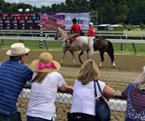 people watching horses at the track