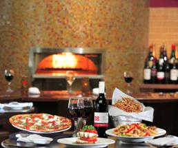 pizza, pasta, and wine near a fireplace in a restaurant