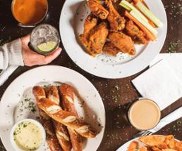 view looking down on table with chicken wings, breadsticks, and dips
