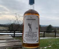 bottle of adirondack blended straight bourbon outside, there's a little snow on the ground