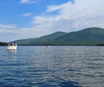 lake george with two boats and mountain views