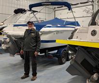 employee standing in front of boats