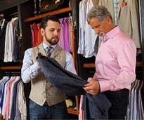 man examining shirt in men's clothing store