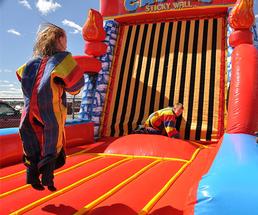 two kids jumping on an inflatable velcro wall