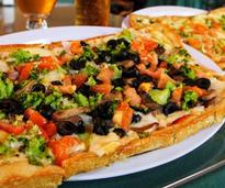 pizza with olives, broccoli, and tomato