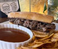 beef sandwich with au jus and chips