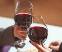 two glasses of red wine cheersing