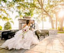bride and groom kissing on a bench outdoors