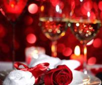 table setting with rose and two glasses of wine