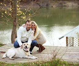 couple posing with their dog