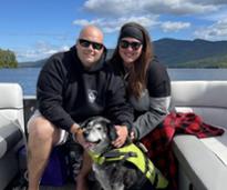 couple with dog on boat in lake george