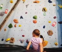 little kid at indoor rock climbing gym