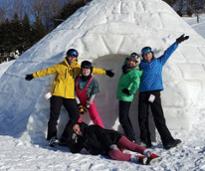 kids pose by a snow mound at mccauley mountain ski area