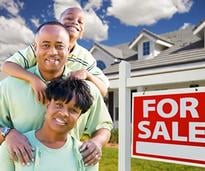 happy family next to house for sale sign