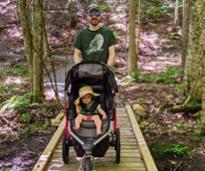 dad and daughter in stroller on a hiking path in gurney lane recreation area