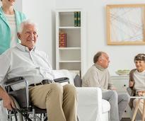 nurse pushing an older man in a wheelchair