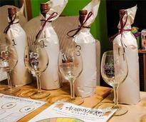 four wrapped bottles of wine with empty glasses