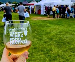 person holding an adirondack wine and food festival wine glass