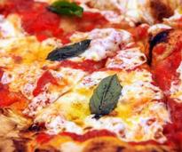 close up photo of pizza with cheese and basil
