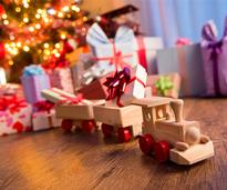 toy train with other gifts under a christmas tree