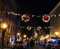 holiday wreaths and lights hanging above city street