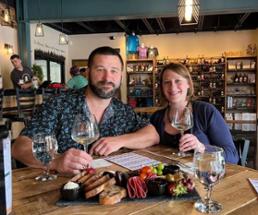 man and woman at a table in a winery tasting room