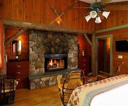 a rustic guest room with a stone fireplace