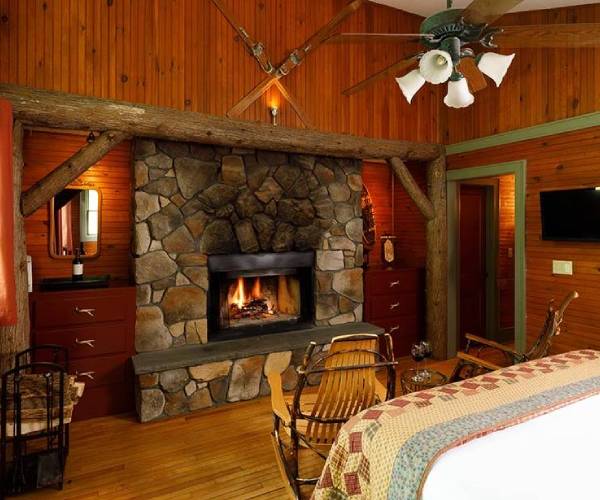 a rustic guest room with a stone fireplace