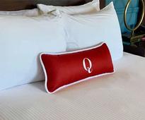 red q pillow on a hotel room bed