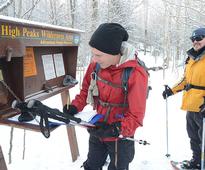 two hikers signing in at a trailhead in the winter