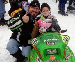 man and little girl on snowmobile