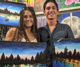 a couple holding paintings