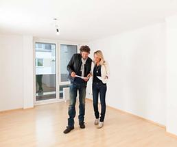 couple in an apartment with white walls, hardwood floors and sliding glass doors