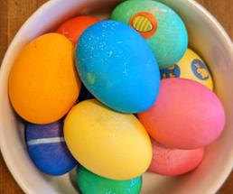 colored easter eggs in a white bowl