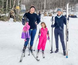 two women and a young girl in skis