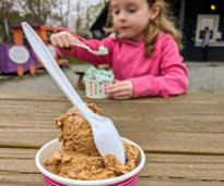 coffee ice cream in foreground, little girl eating ice cream in background at sprinkle's ice cream shop