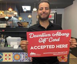man holding up a red gift card sign