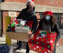 two people donating holiday gifts