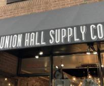 exterior of union hall supply co with name on awning 