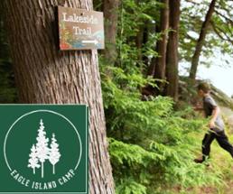 kid runs on trail near camp sign