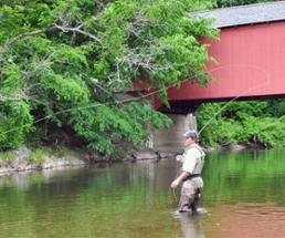 man fly fishing in a river