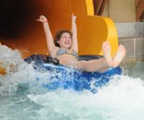 girl coming out of a water slide on a tube