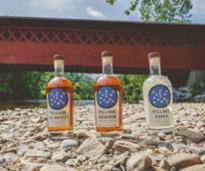 three bottles of spirits placed below a covered bridge