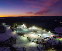a photo of a ski mountain with a sunset behind