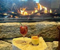two cocktails by a fire in fireplace