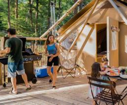 family at a glamping tent in the woods