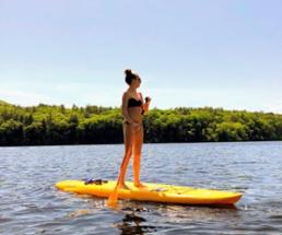 woman on a stand up paddleboard on the water