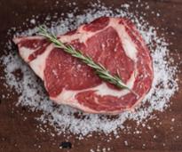 raw steak with salt and rosemary